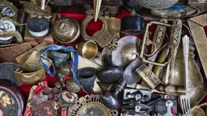 Un étalage diversifié d'antiquités et d'objets vintage sur un marché local ensoleillé.