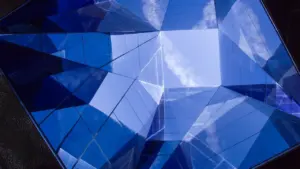 Reflets géométriques bleus sur une structure vitrée moderne à Dijon.
