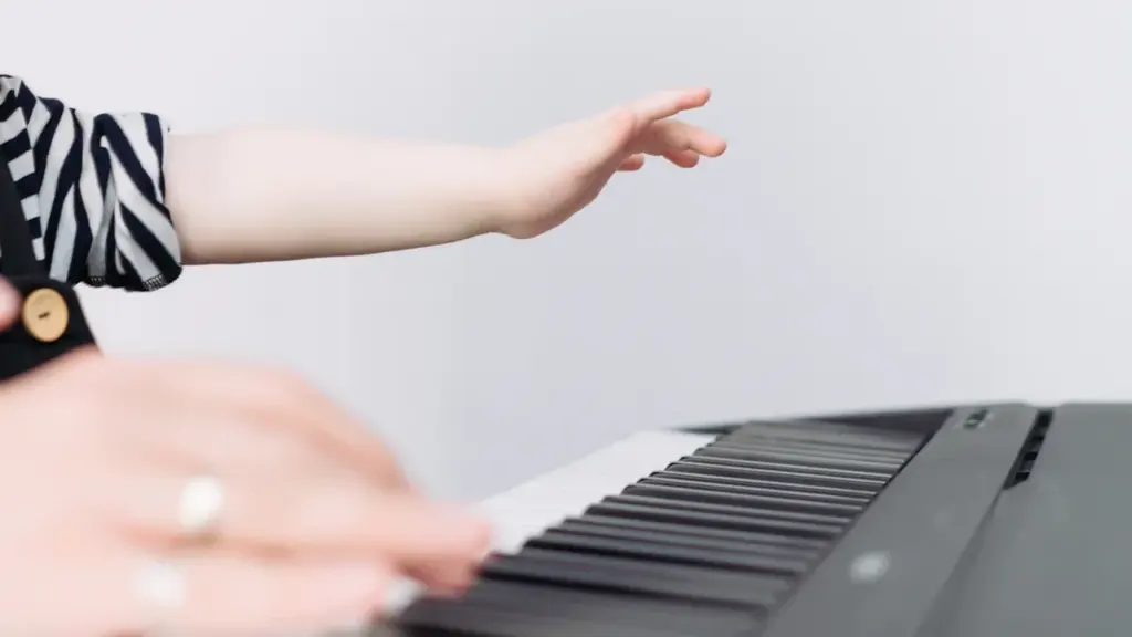 Gros plan sur les mains d'un enfant jouant sur un clavier de piano