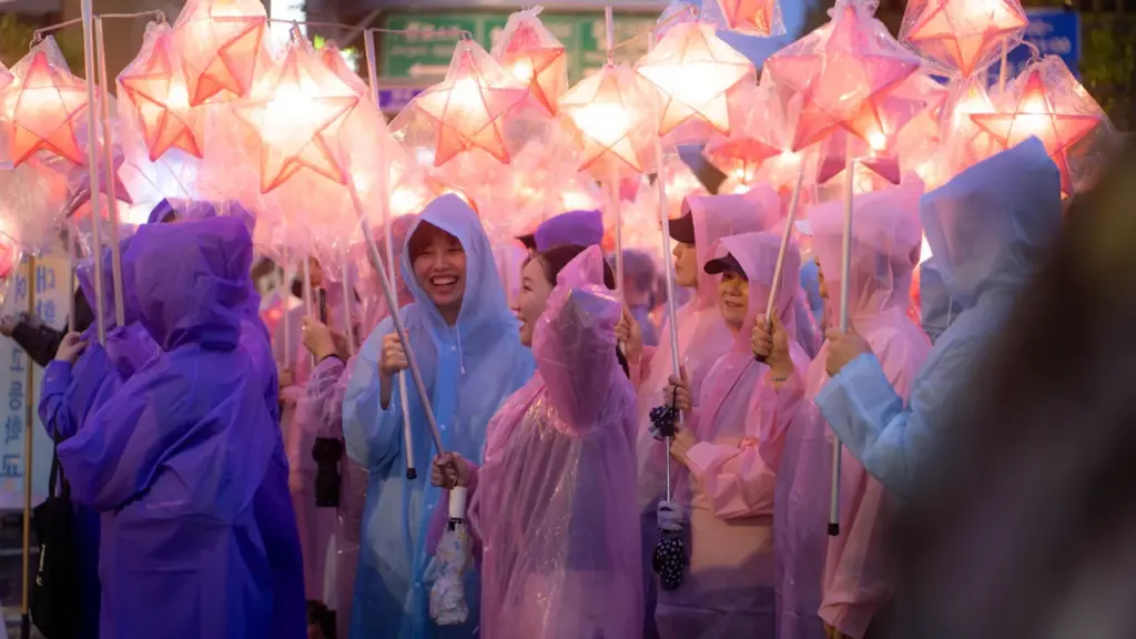 Foule joyeuse portant des imperméables colorés avec des lanternes lumineuses à Nanterre
