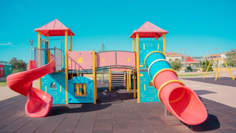 Structure de jeu moderne sur sol stabilisé dans un parc urbain ensoleillé.