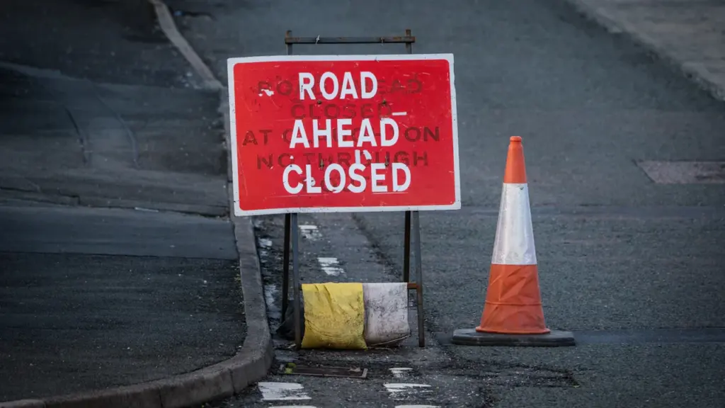 Un panneau de signalisation indiquant une route fermée avec un cône de chantier.