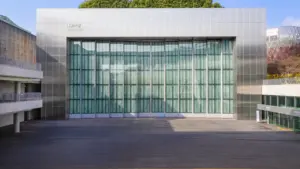 Façade vitrée moderne d'un théâtre urbain ouverte pour un spectacle en plein air.