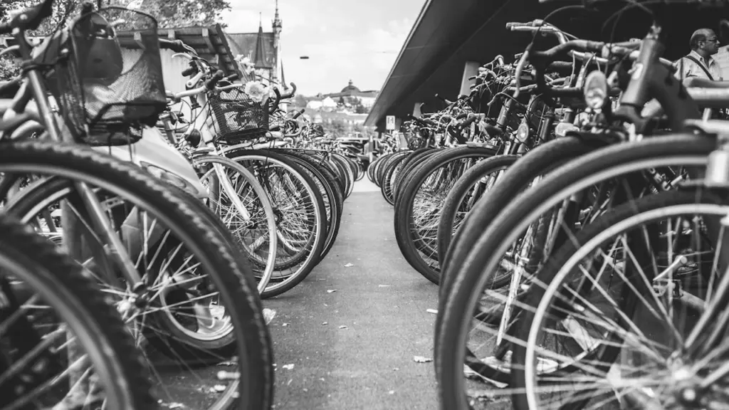 Plusieurs vélos garés dans un rack urbain, vue en noir et blanc.