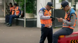 Agents de sécurité en gilet orange en mission de surveillance sur la voie publique.