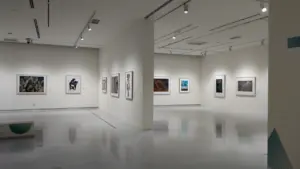 Vue d'une galerie d'art moderne avec des cadres accrochés sur des murs blancs.
