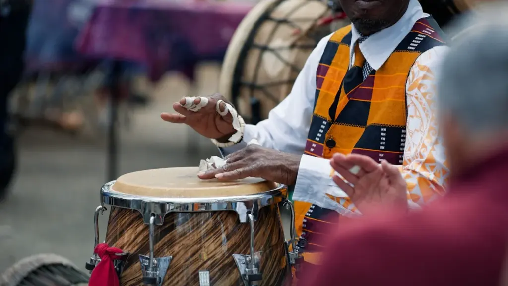 Un musicien joue des percussions lors d'un événement en plein air.