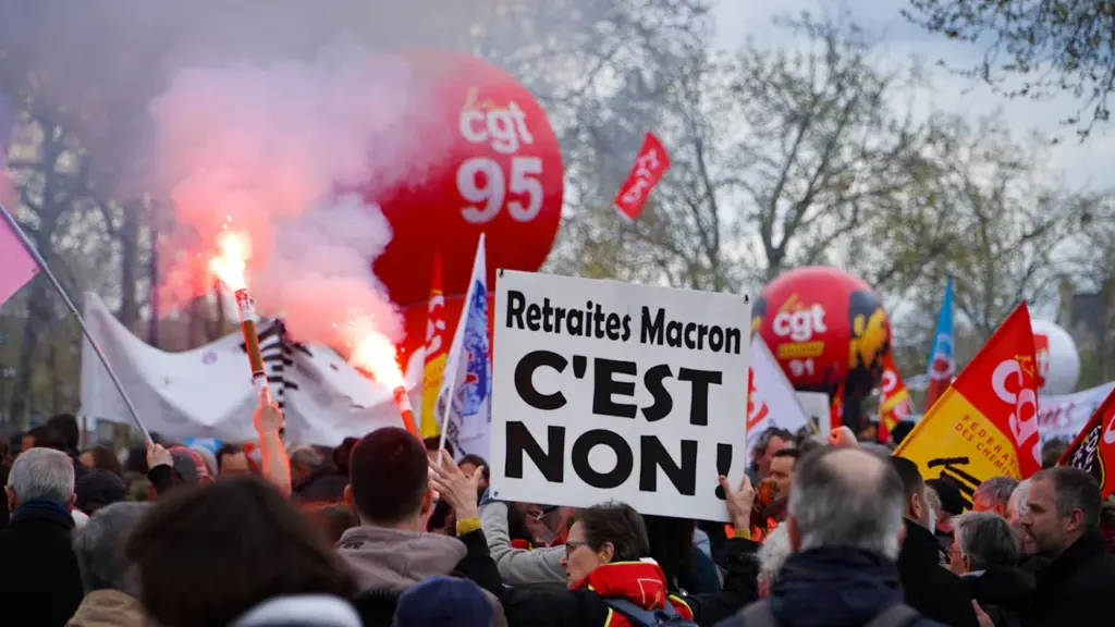 Manifestants portant des pancartes syndicales et des fumigènes lors d'une manifestation à Paris.