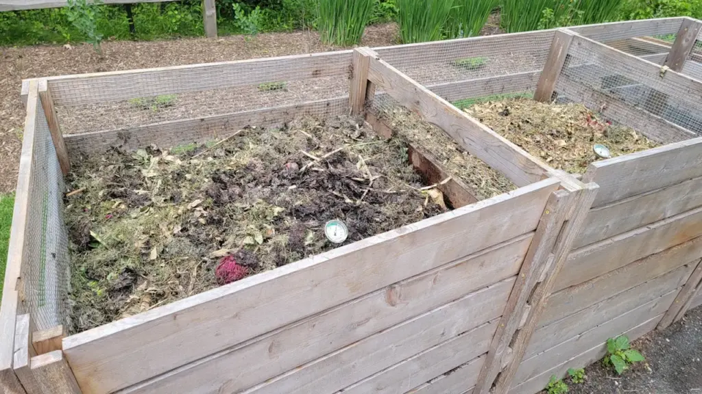 Un système de compostage en bois rempli de matières organiques en décomposition.
