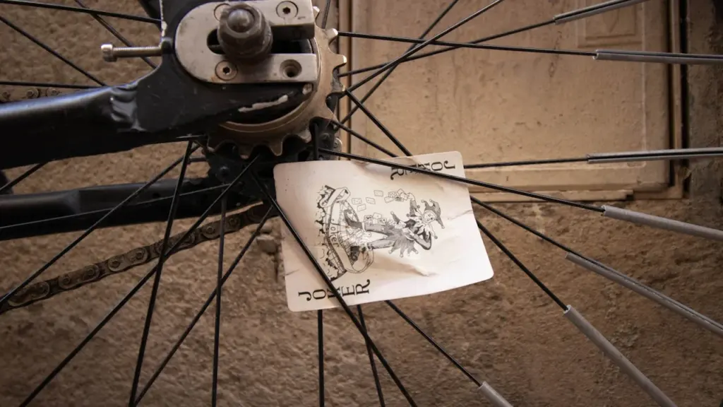 Gros plan sur une carte à jouer coincée dans les rayons d'une roue de vélo.