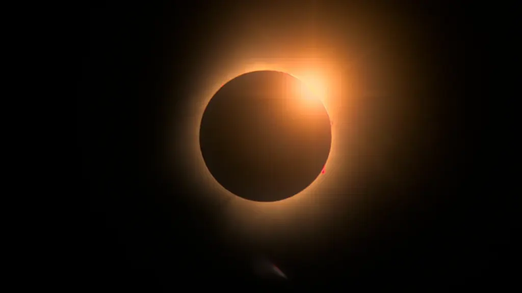 Une éclipse solaire totale avec un cercle noir entouré d'une fine couronne lumineuse dorée.
