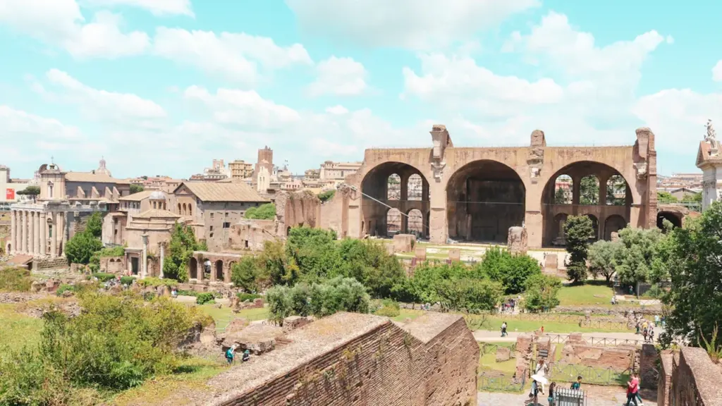 Vue aérienne panoramique des vestiges romains emblématiques sous un ciel bleu d'été.