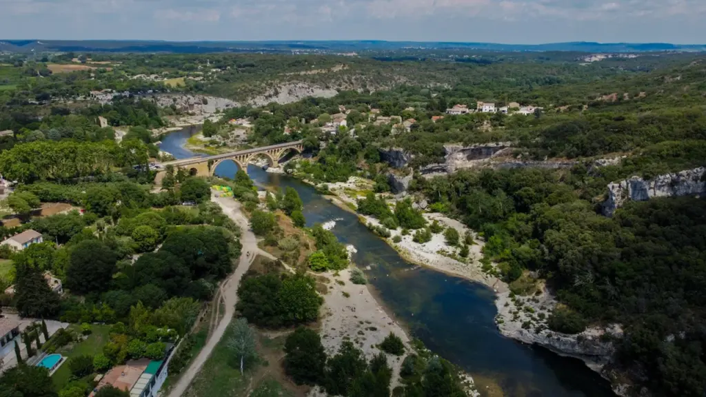 Vue aérienne d'une rivière serpentant à travers la végétation luxuriante près de Nîmes.