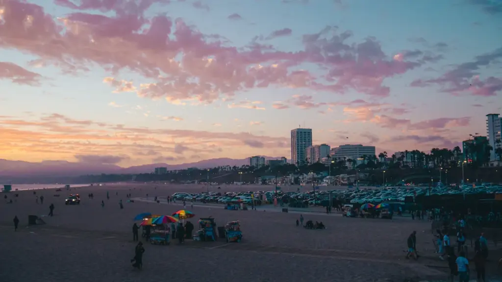 Ciel au coucher du soleil au-dessus d'une plage urbaine et de ses bâtiments.