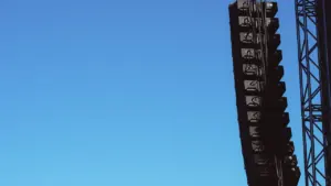 Installation de haut-parleurs suspendus pour un événement culturel en extérieur.