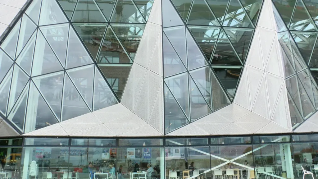 Façade en verre géométrique d'un bâtiment moderne et innovant au design contemporain.