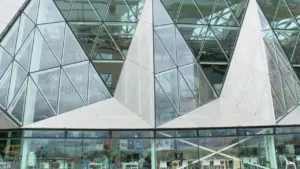 Façade en verre géométrique d'un bâtiment moderne et innovant au design contemporain.